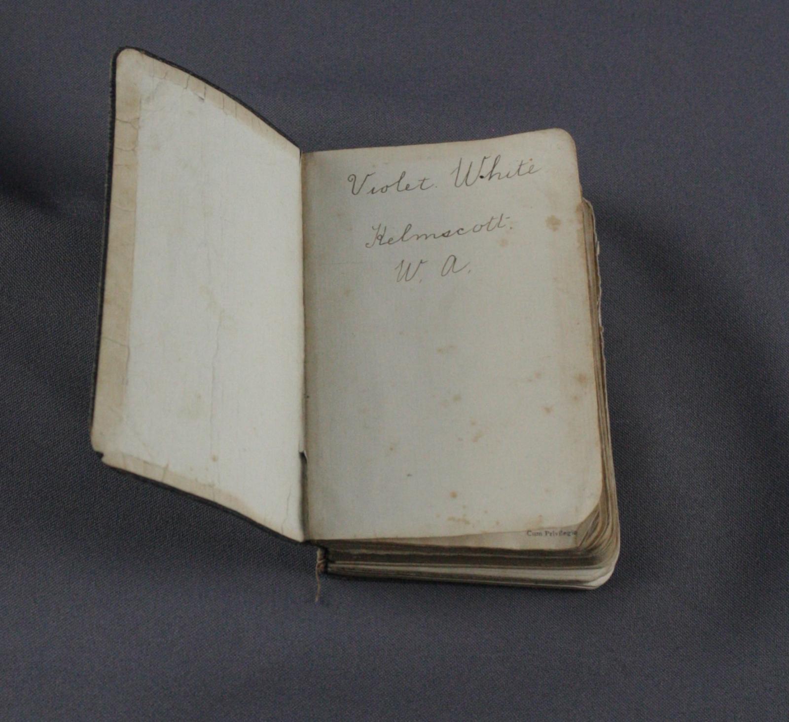Open book to blank first page, with text written in pen 'Violet White Kelmscott W.A.'