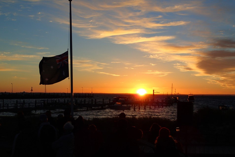Sunrise with Australian flag in shadow at half mast for Anzac Dawn Service