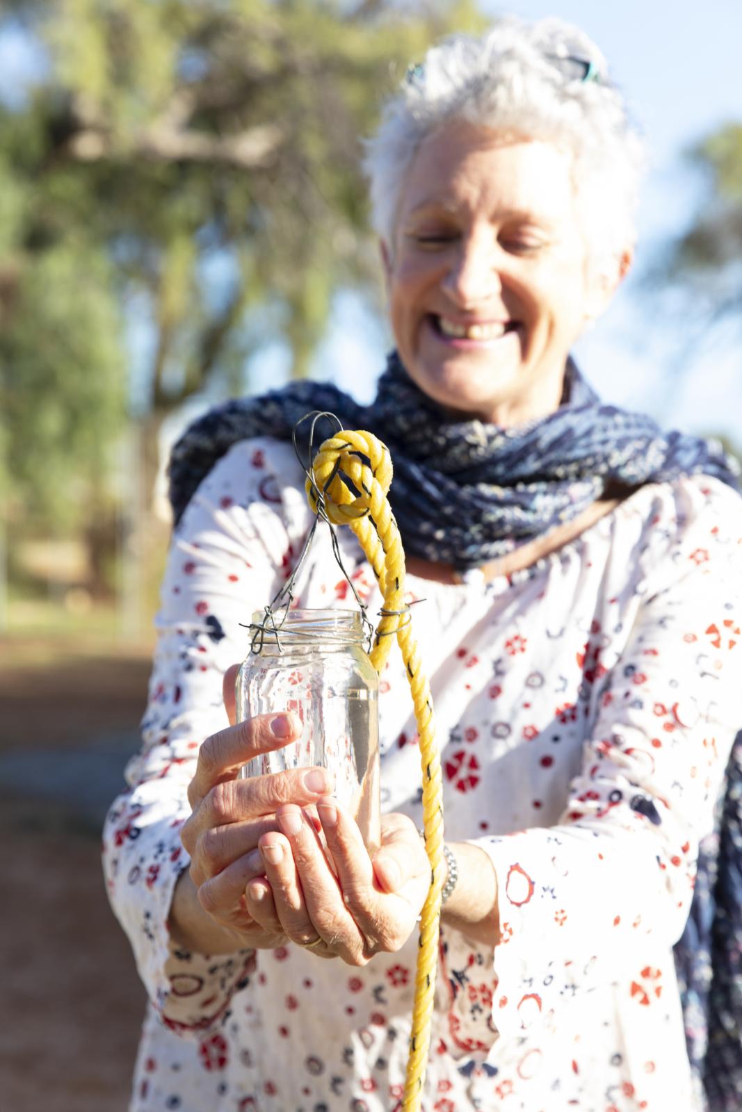 Woman holds jar of water in hands.