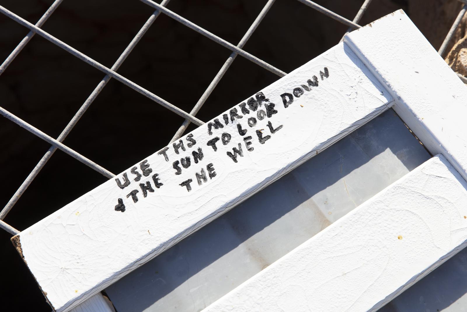 Hand written instructions on mirror frame of how to use mirror to look into the well.