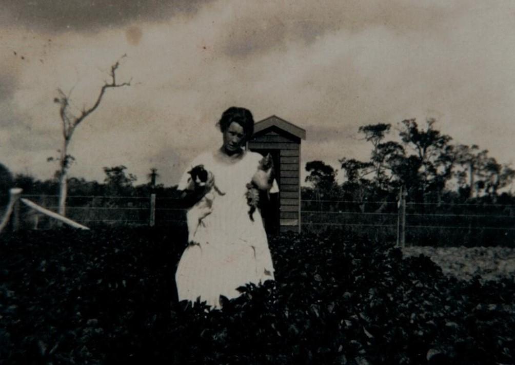 The Pan Lavatory can be seen behind Mrs Lilly Coates, holding her cats, in the potato patch at Group 52, Lennox.