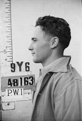 Side on head shot of Prisoner of  War with number on sign