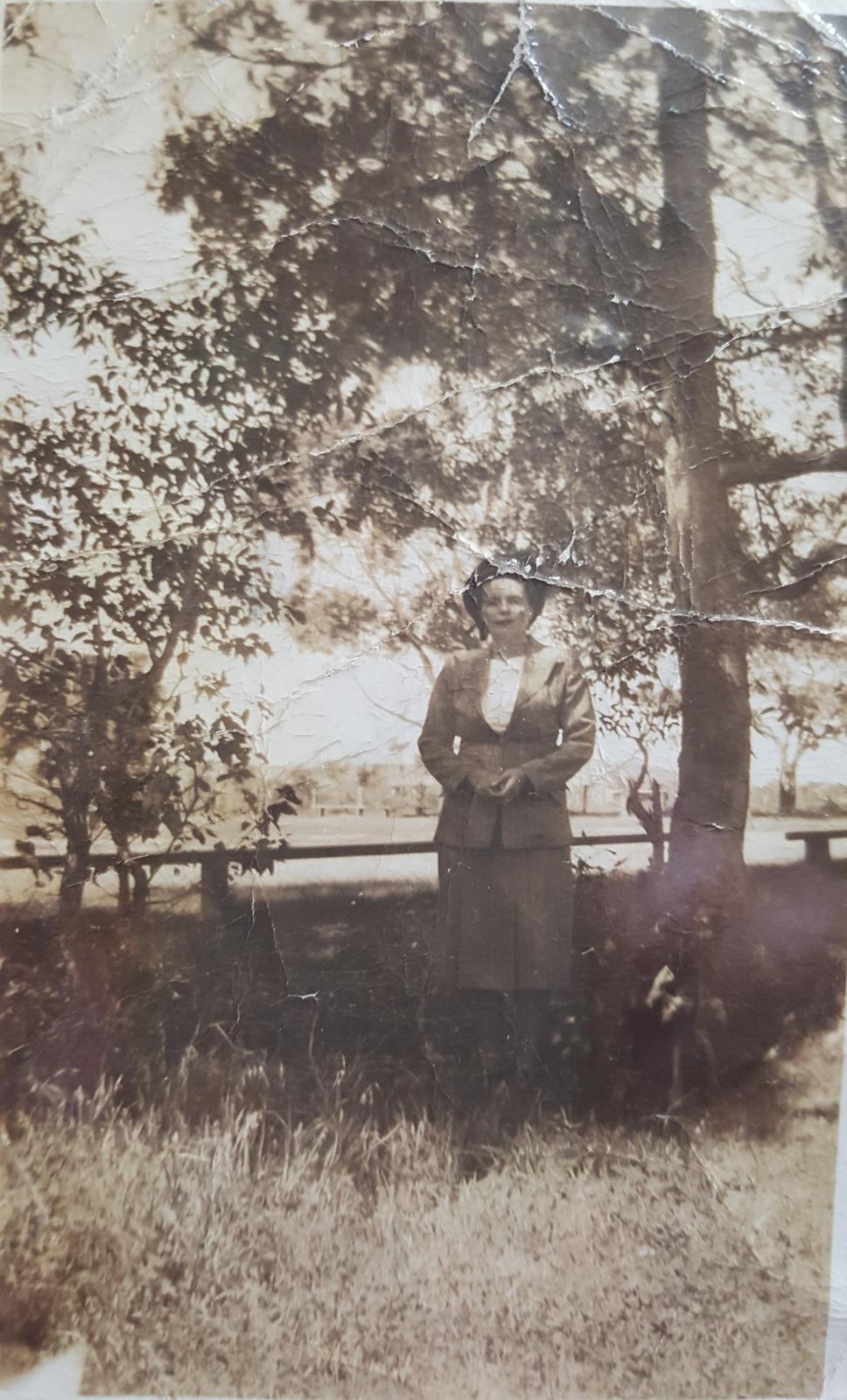 Shylie Walker and her kelpie dog standing in front of Middle Swan Oval, 1947. The oval is now called Jack Mann Oval.