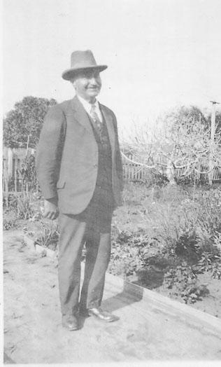 Black & white photograph of Tom Duncan standing in a garden