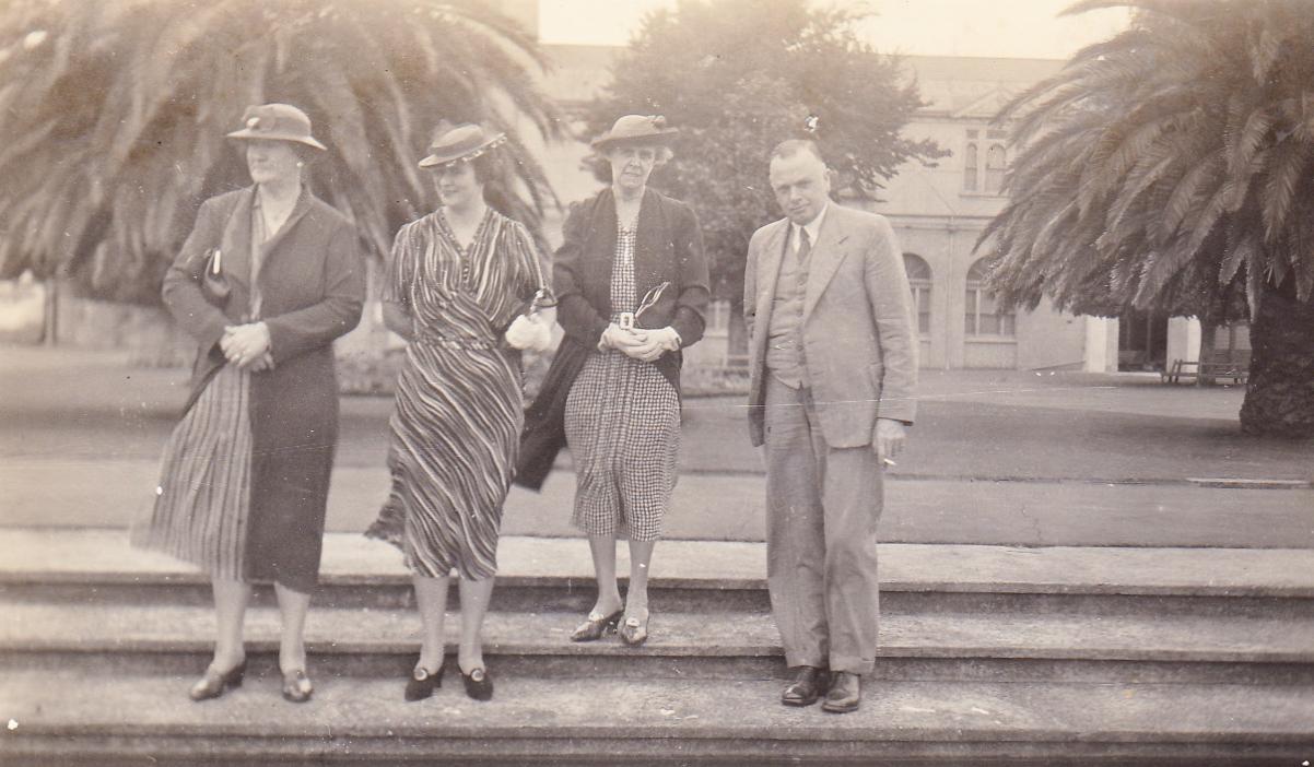 Photograph of three women and a man on steps in a park