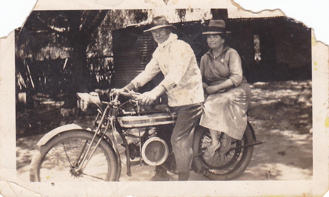 photograph of a man and woman astride a motorbike