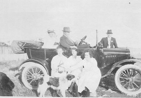 Photograph of group of friends with a car