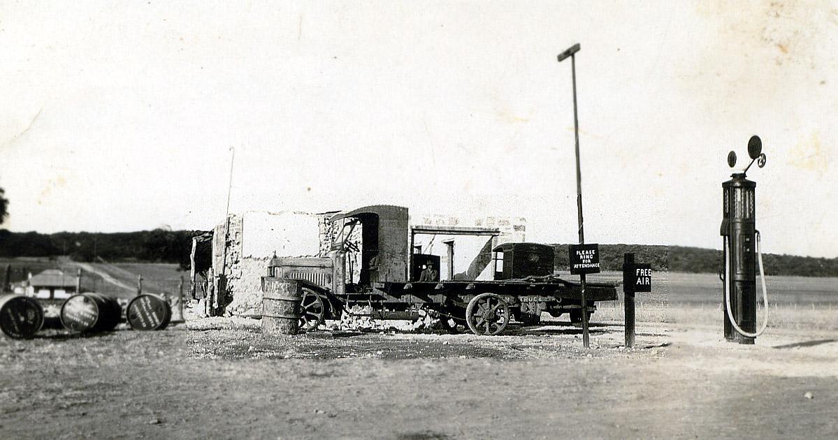 Black & white photograph of a wrecked truck in front of a ruin