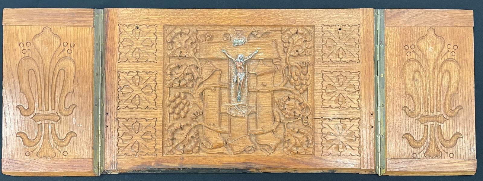 Carved wooden case.  Case has two sides and a back piece which has a crucifix displayed in the middle.  