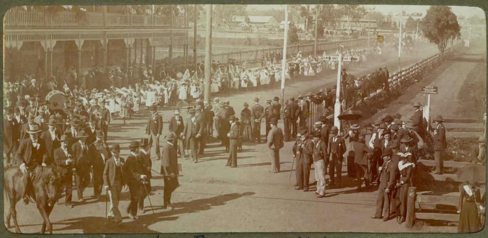 P100-03. Coronation procession moving around from Helena Street to Commercial Road (Great Eastern Highway) in front of the Freemasons Hotel.