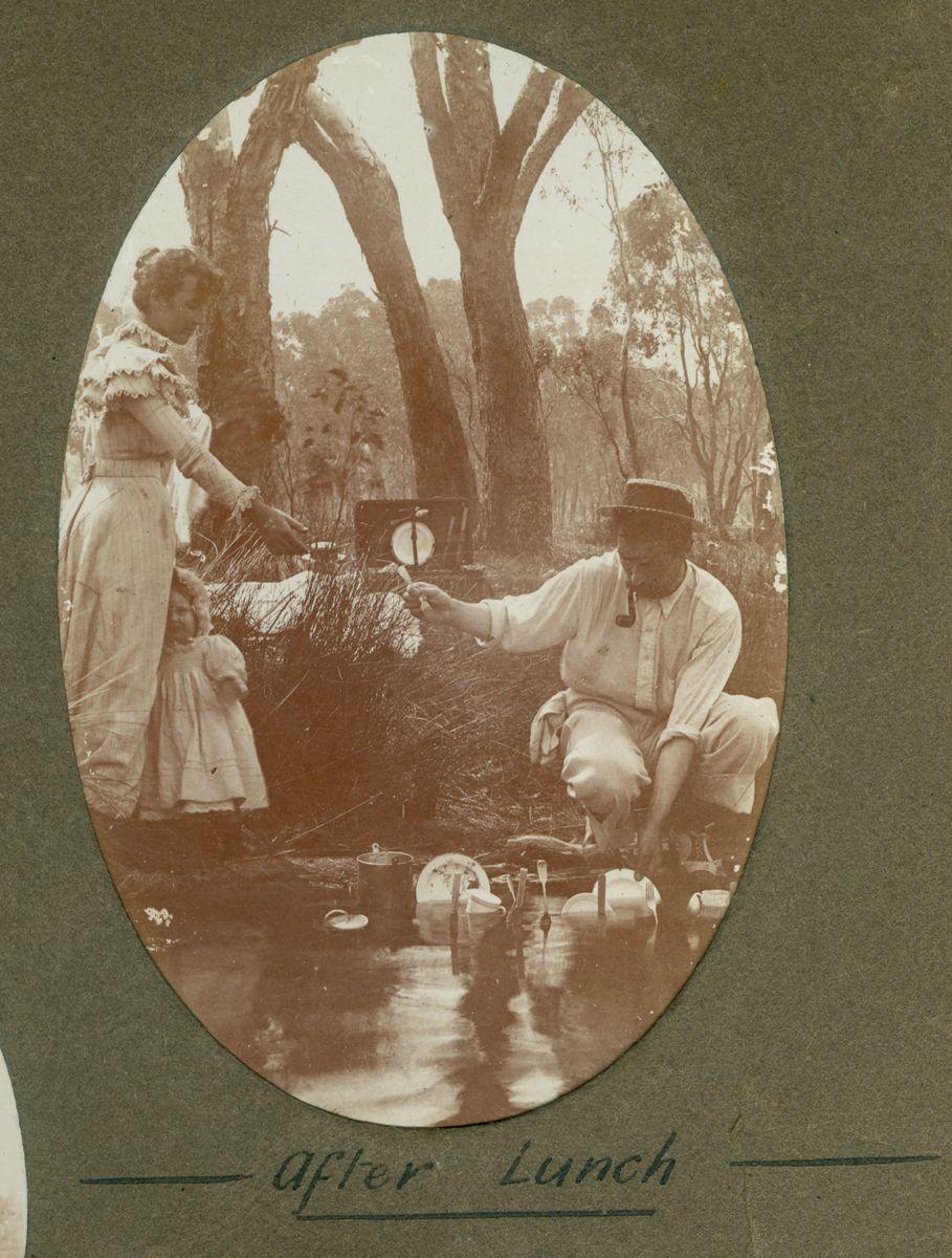 P100-30. Elise and William Dawson with their daughter Dorothy washing dishes in the river after lunch.