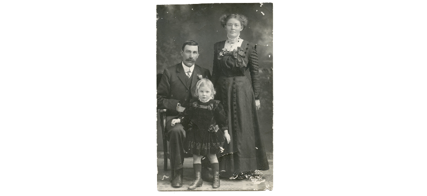 Photograph of Buckingham family from about 1910. The father, Henry, is seated to the left and his wife, Lucy, standing at the right. Daughter Sybil is standing in front