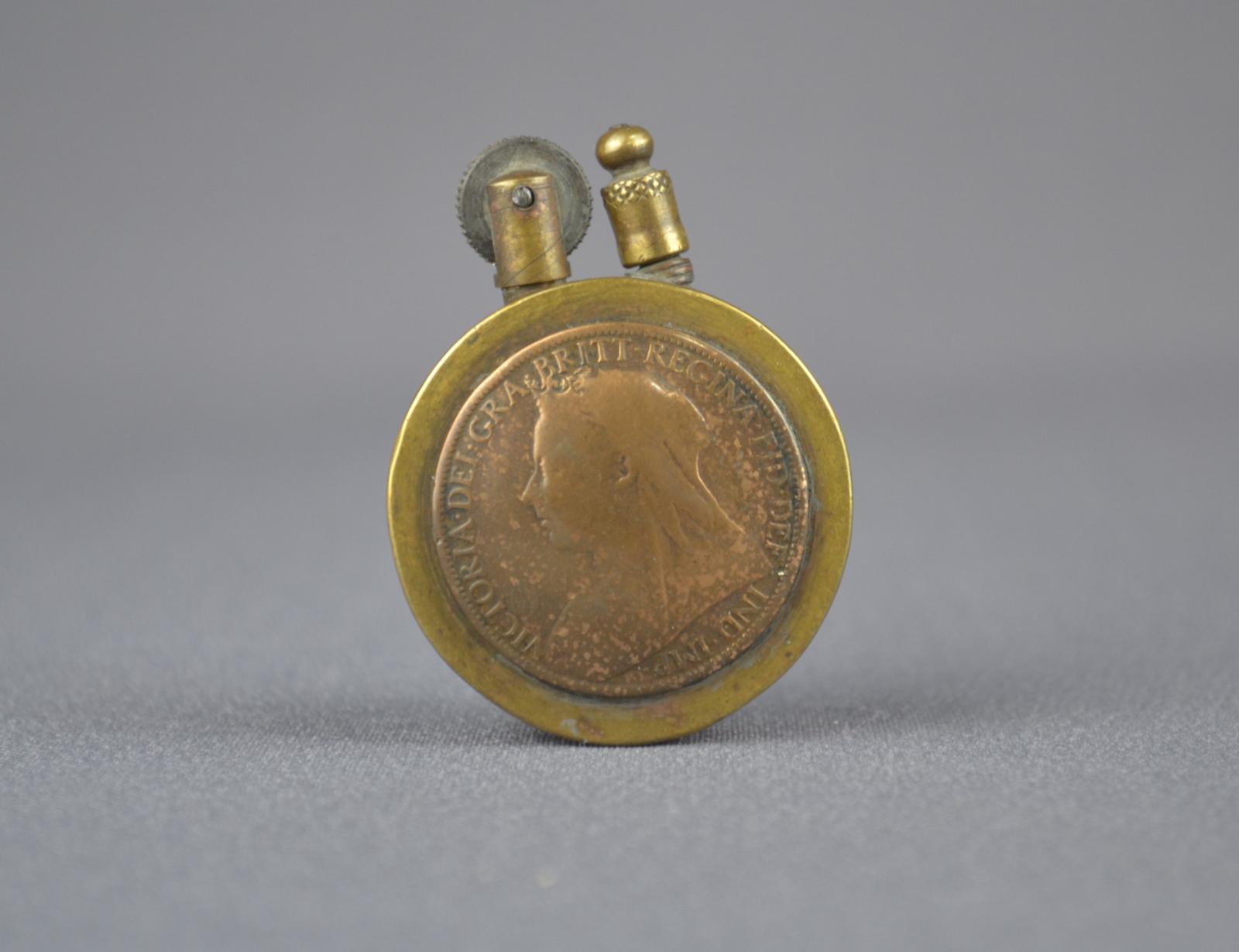 Obverse view of trench made cigarette lighter showing a coin featuring Queen Victoria I