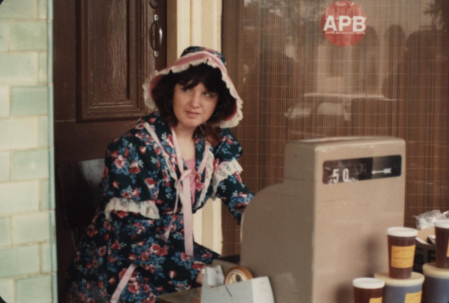 young woman in colonial dress at a street stall