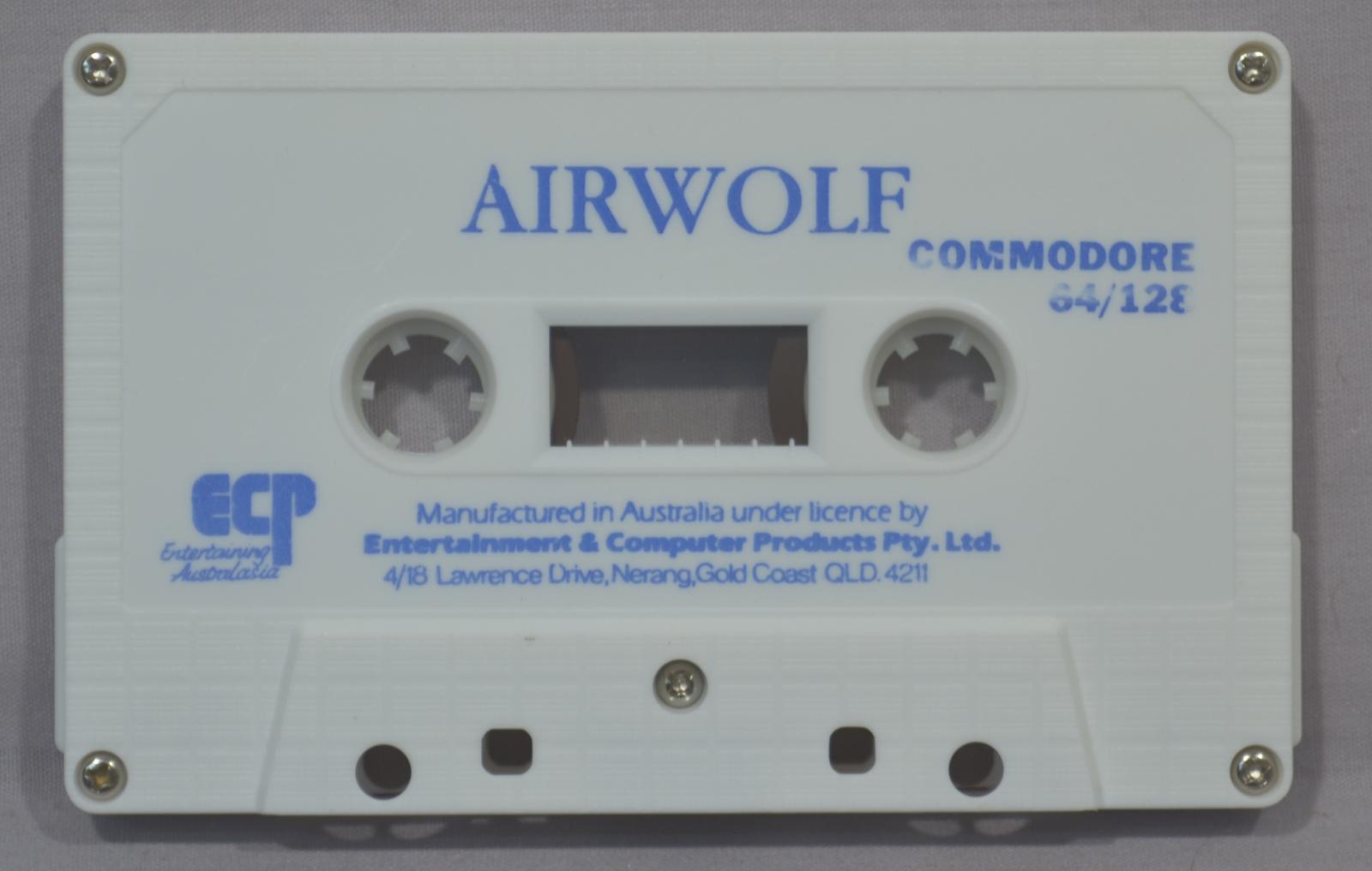 Rectangular white plastic cassette, with game title Airwolf in blue printing at the top of the cassette and manufacturing and publishing information in blue printing at the bottom