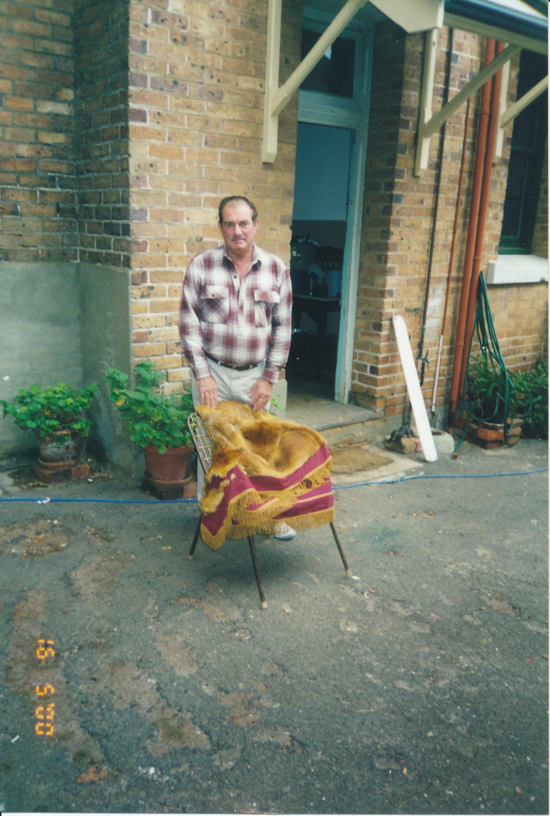 Man standing behind a chair with the Fox Skin Rug on it