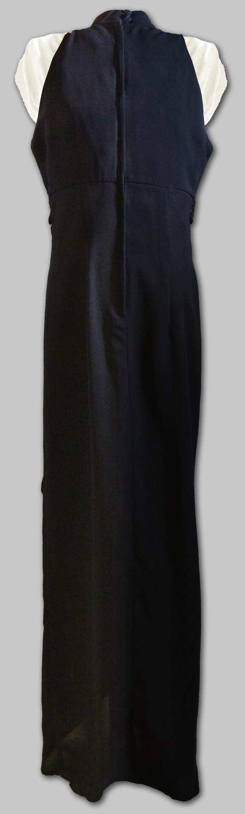 Back of long black crepe dress with wrap-over front, no sleeves, with cut-away shoulders and a long zip