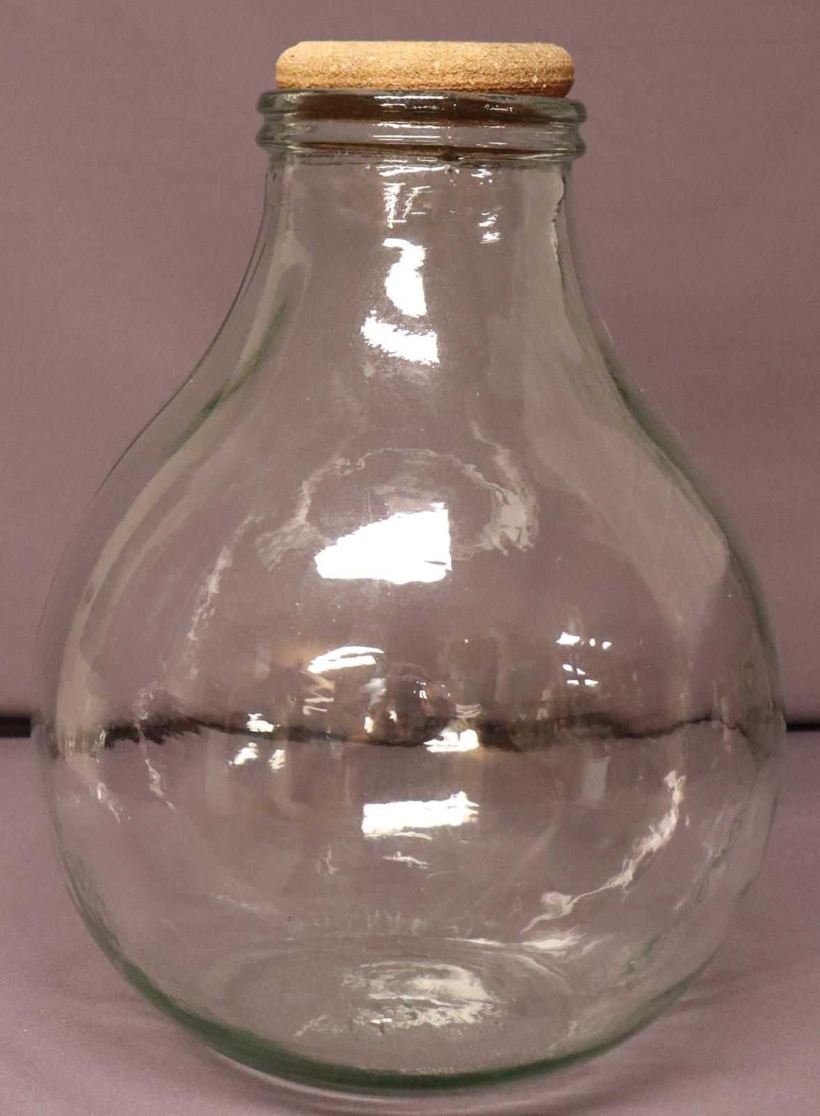 clear glass bulb shaped terrarium with a flat base. Top tapers up to a round opening. round cork stopper in the opening