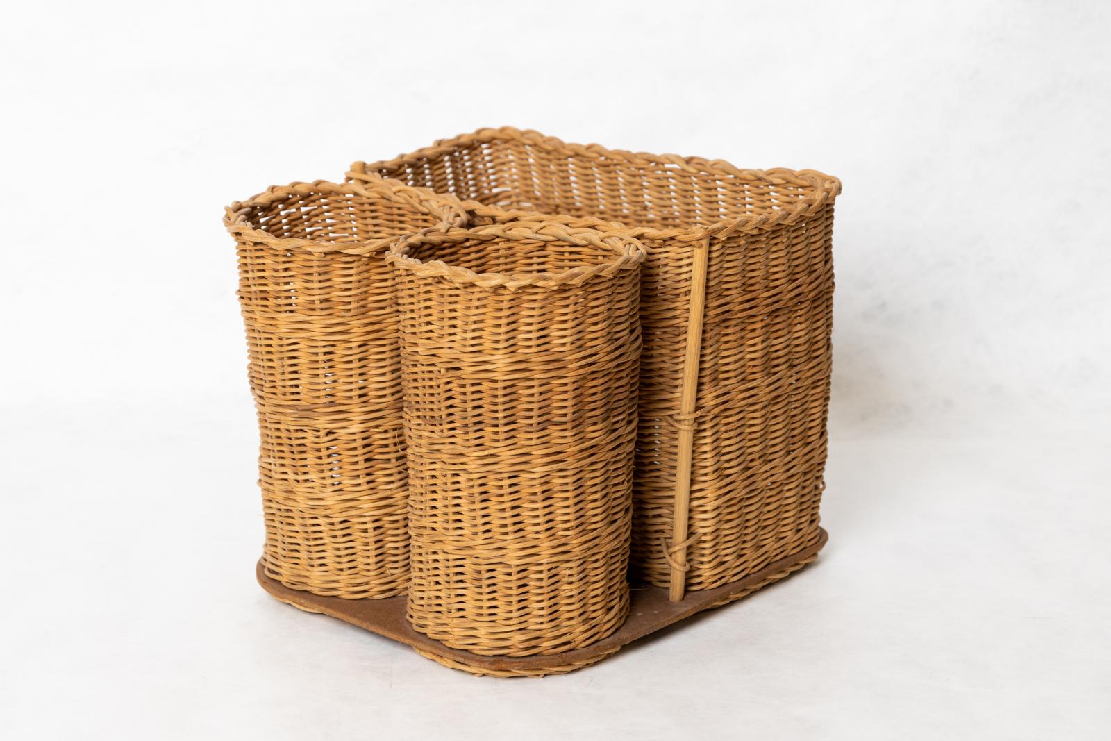 Cane picnic basket with rectangular section and two cylindrical sections for bottles, base woven to square piece of dark brown Masonite with rounded corners.