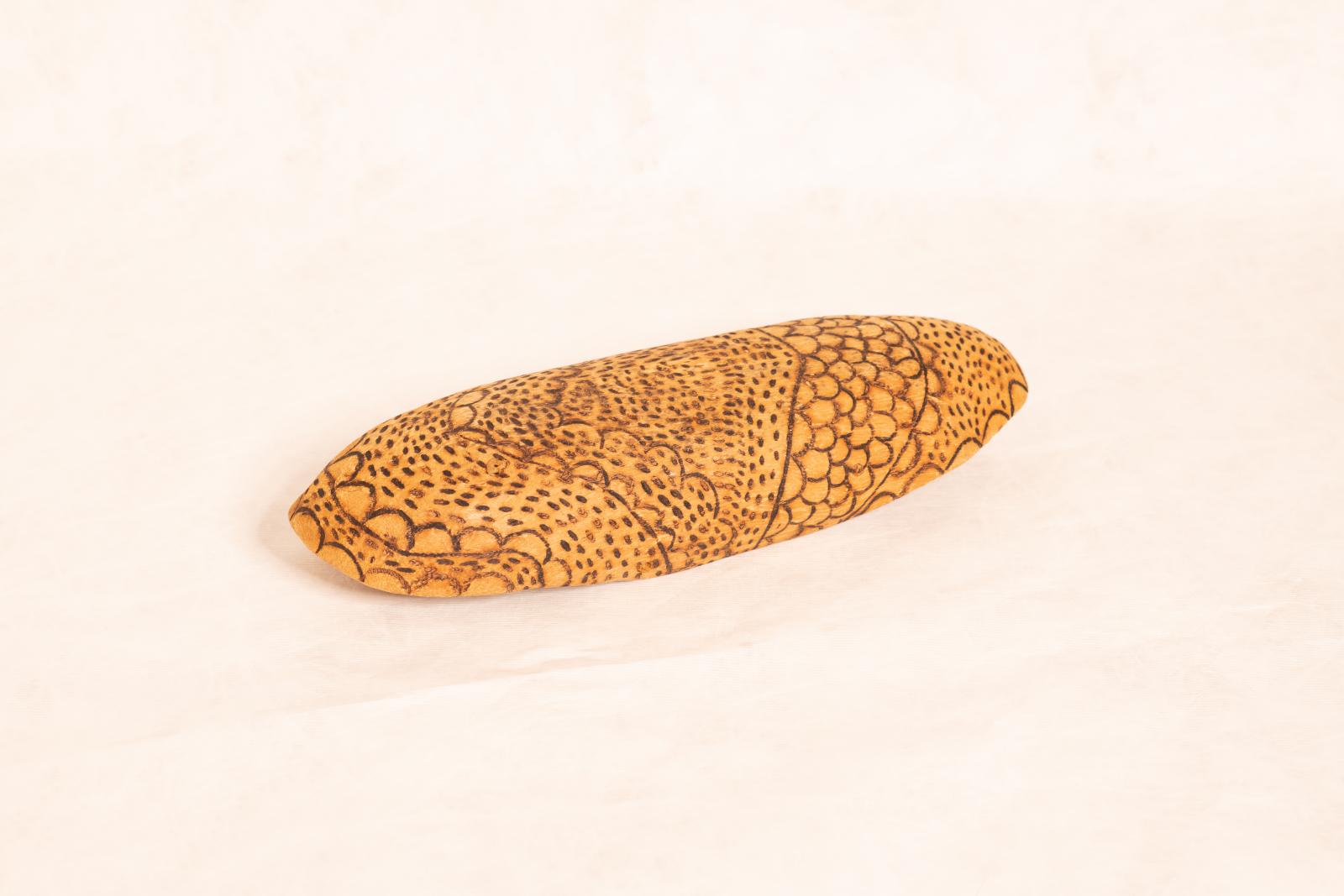 Carved beige wooden dish, Yandi, with rounded ends, curved up sides and flat base. Small lines, circles and dot patterning burnt into inside and outside surfaces.