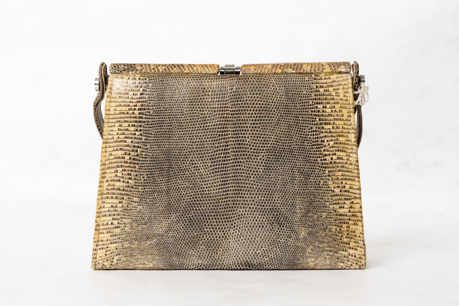 Yellow, dark brown and black snakeskin handbag with short strap and metal clasp on top. The interior is possibly brown leather and is divided into two compartments. The first compartment has two additional pockets and the other compartment is divided into two with one zipped pocket, between these compartments is a zipped pocket.