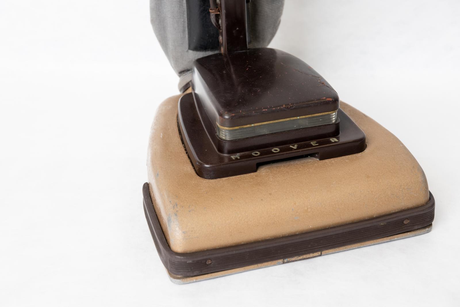 A close up image of the base of the vacuum which is light brown with a dark brown edging and a smaller dark brown box on the top of the base.