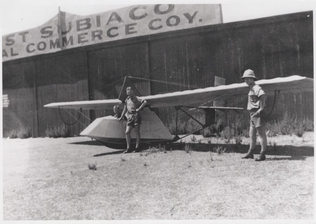 two men standing in front of small aeroplane