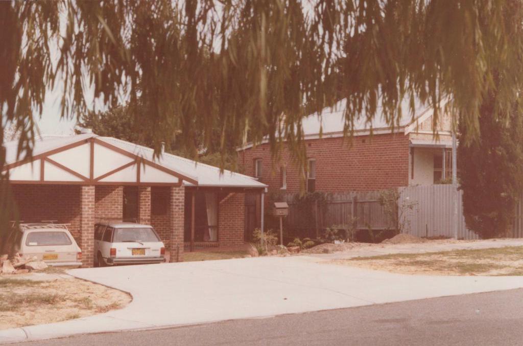 view of front of house with trees and cars out front