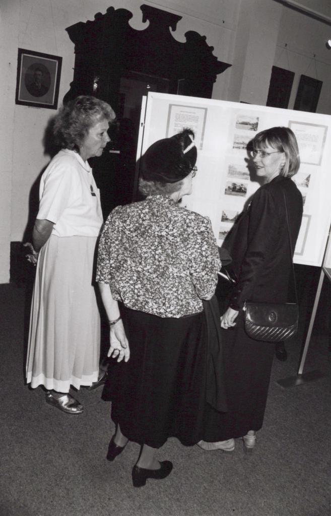 black and white photo of three women standing and talking