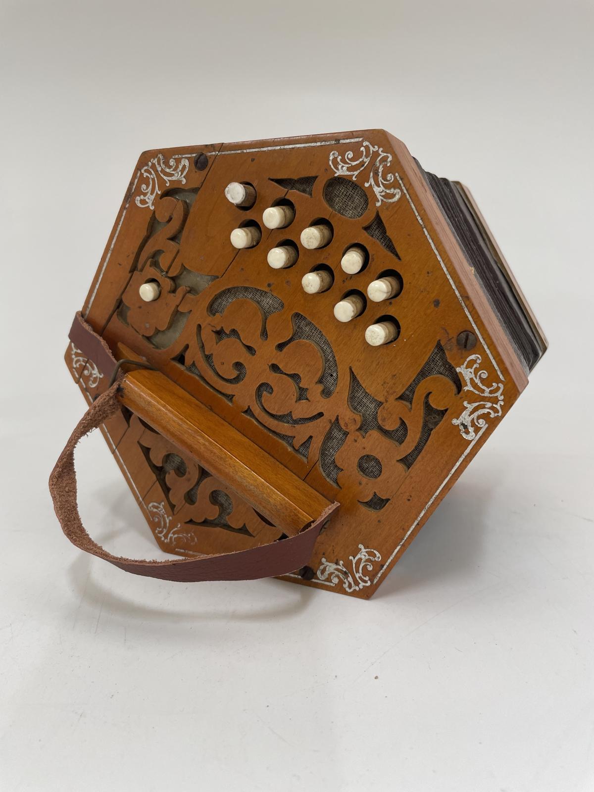 Concertina left hand end showing the silver inlay work and 11 buttons