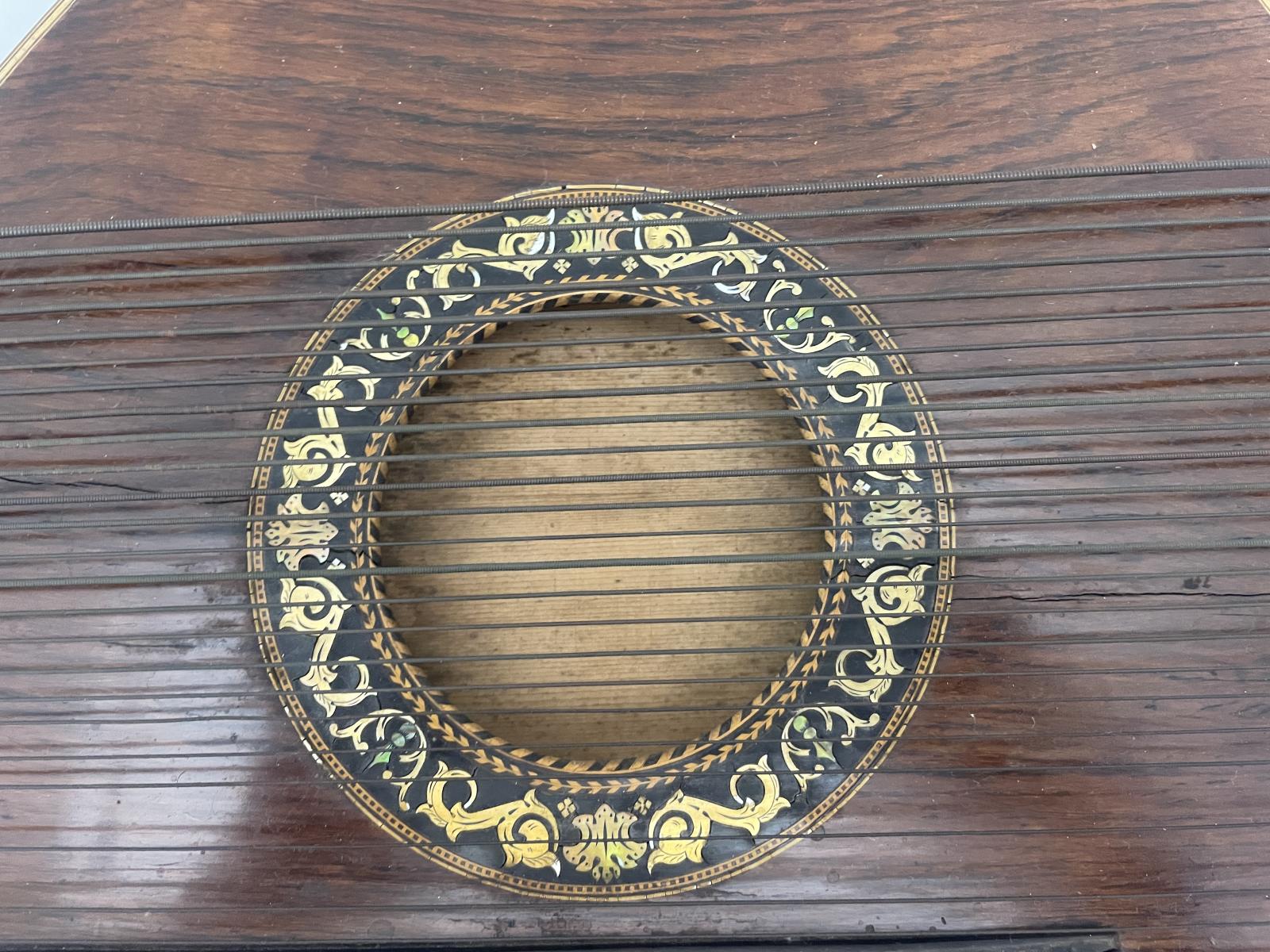 Decorative inlaid patterning surrounding the central sound hole of the Zither