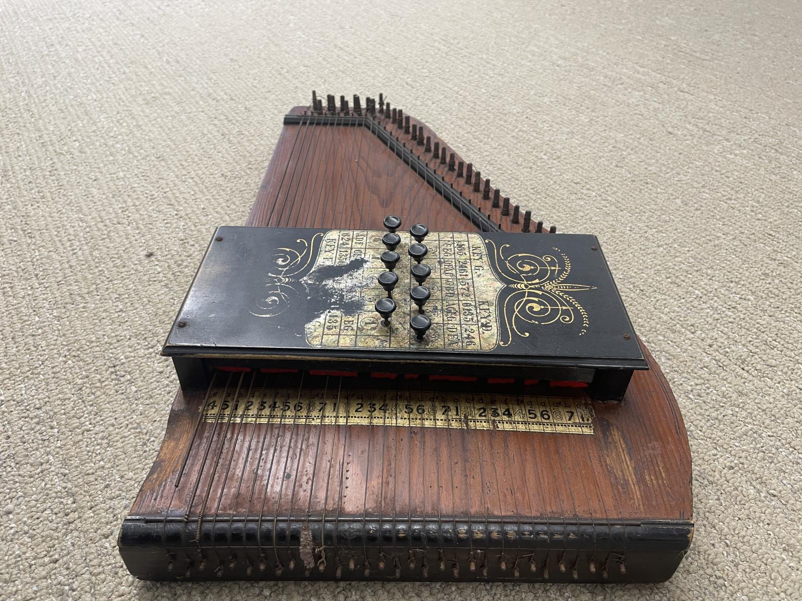 Autoharp end view showing height of the chord box, note / string numbering and metal string nuts