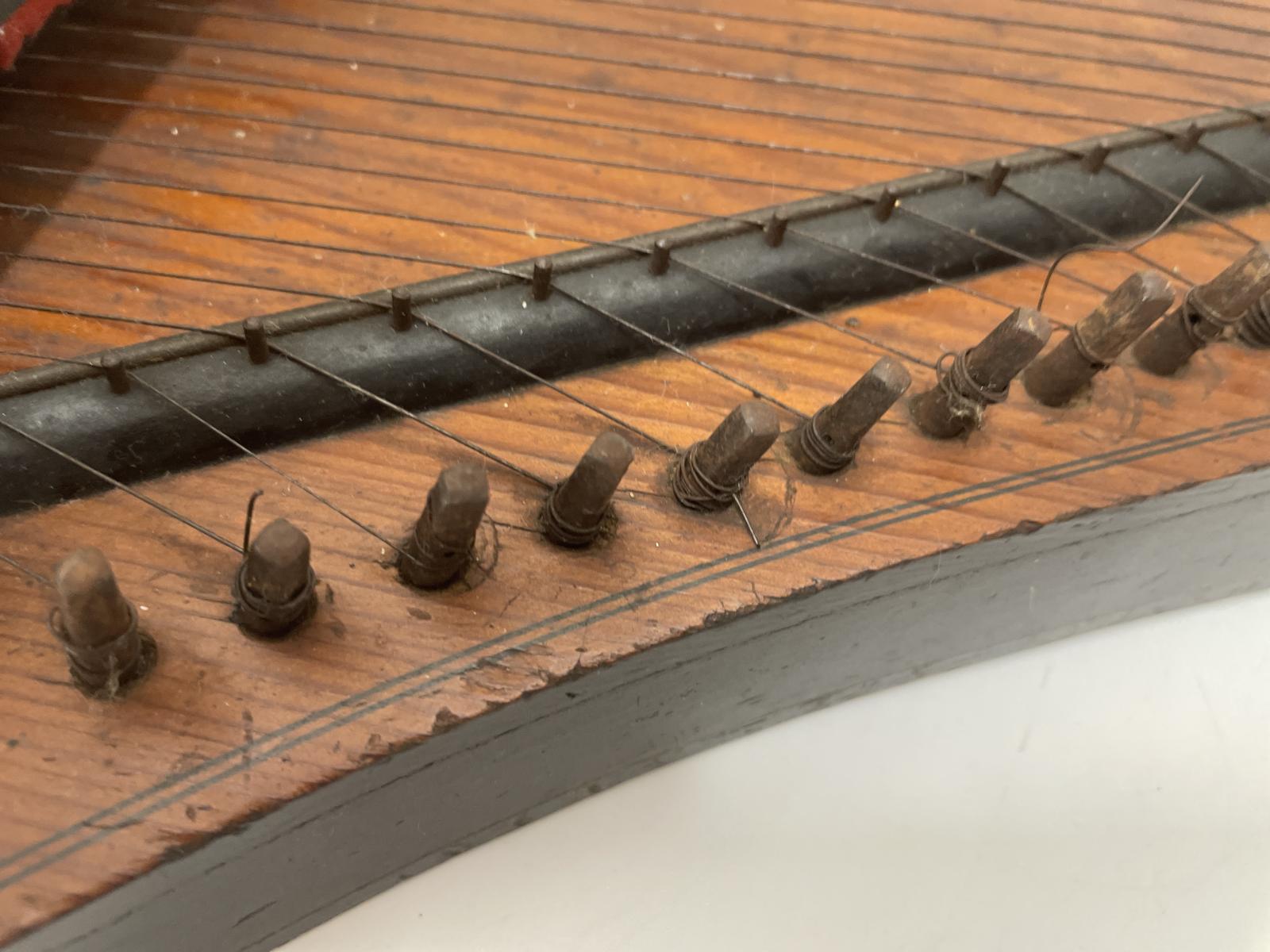 Wooden string tuning pegs on the shaped edge of the Autoharp