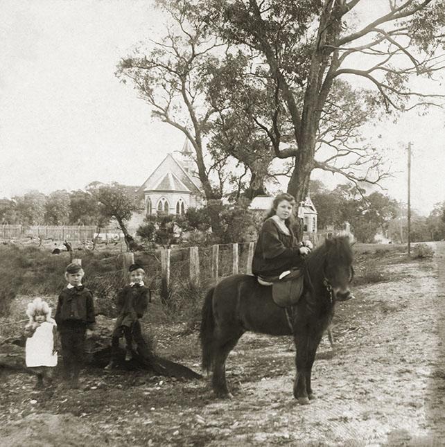 Mabel King sitting on pony - 2 brothers and a sister standing 1898