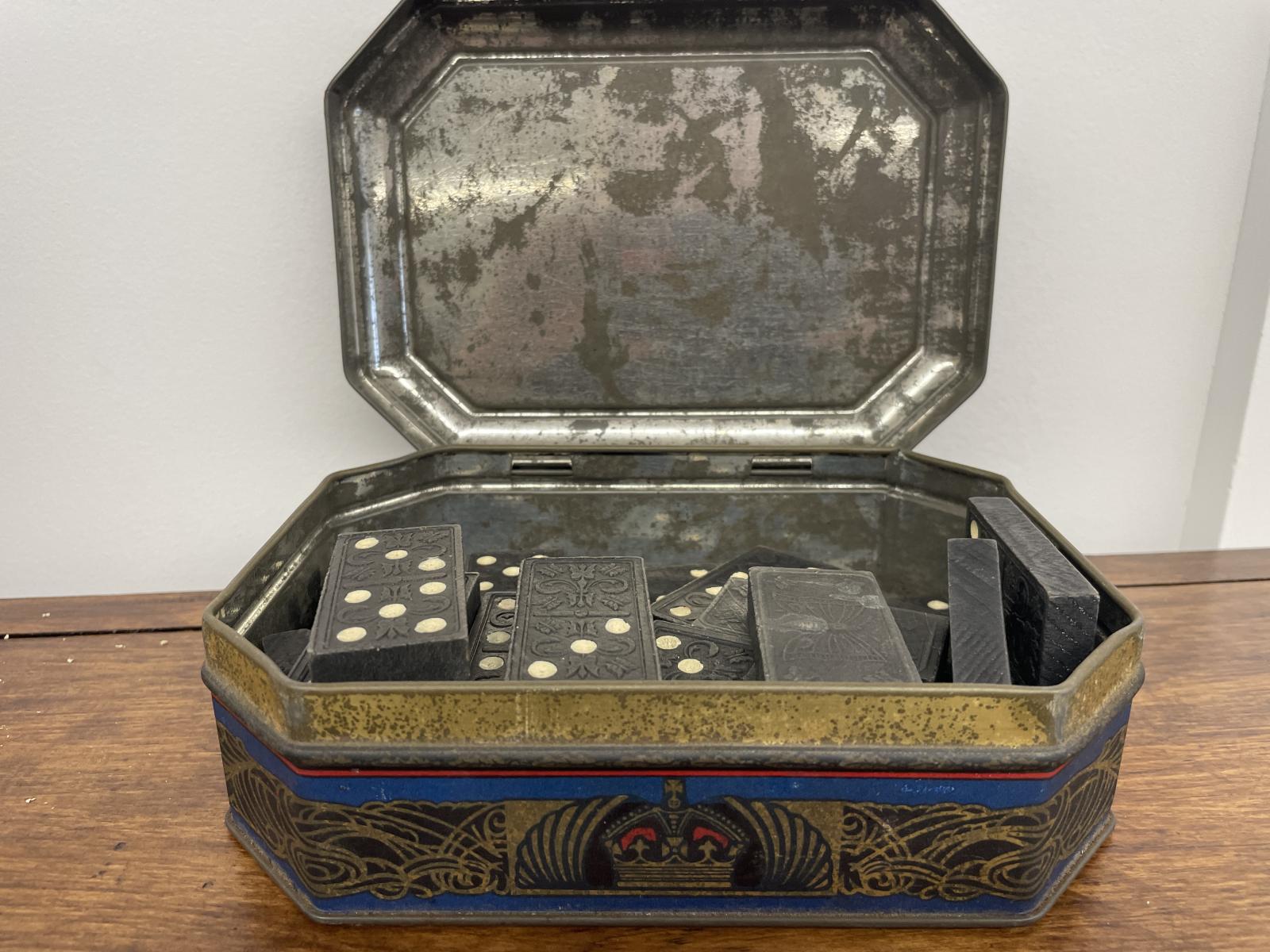 The biscuit tin was used to store dominos before it was donated