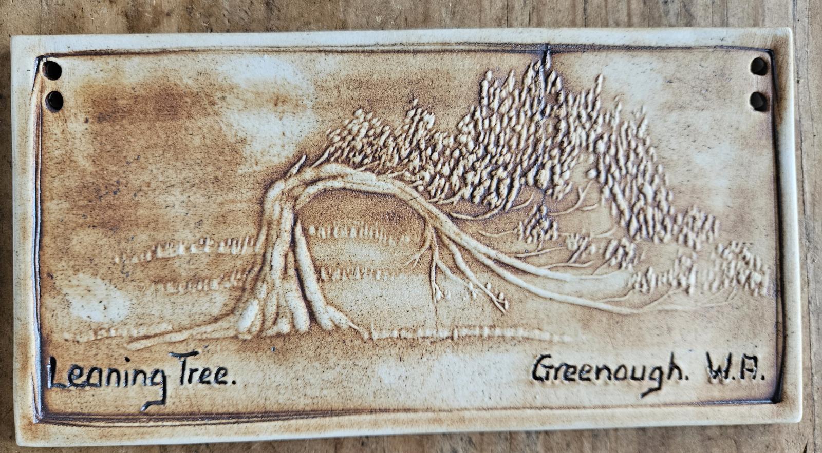 Ceramic wall plaque with an image of a leaning tree at Greenough