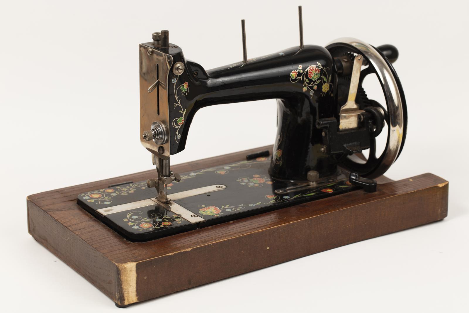 A black sewing machine on a wooden base