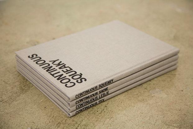 Image of four books stacked. Cover is light brown with the title of each volume on the spine in black and on the front cover. The book on the top of the stack has the title "Continuous Squeaky"