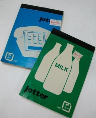 Image of artist's books. Green jotter book is overlapping blue jotter book. The green book has three white milk jugs on the cover with the word 'Milk' in the centre in green. The blue book has a white telephone on the cover. 