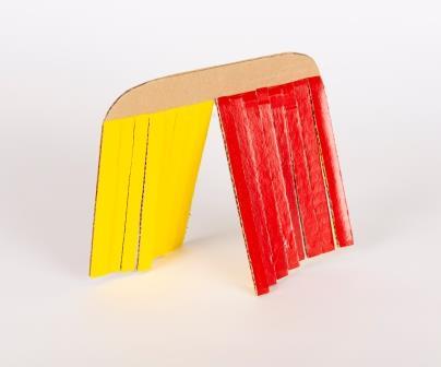 Cardboard folded over forming an arch with the right side painted red and the left side painted yellow