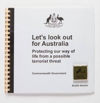 Spiral bound white book with black text "Let's look out for Australia Protecting our way of life from a possible terrorist threat" in the centre of the cover. The Australian Coat of Arms is displayed in the upper centre of the cover in black. In the lower right corner of the book is a yellow CCTV sign