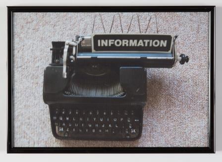 Top-down photo of old typewriter with 'Information' typed on black paper