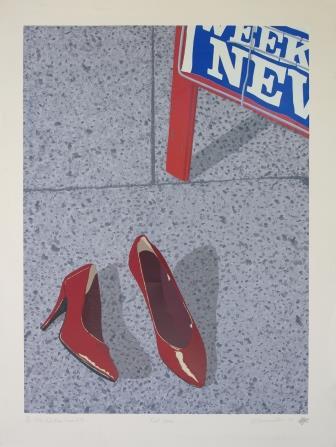 Red high heels on pavement with the edge of a shop sign in the upper right corner