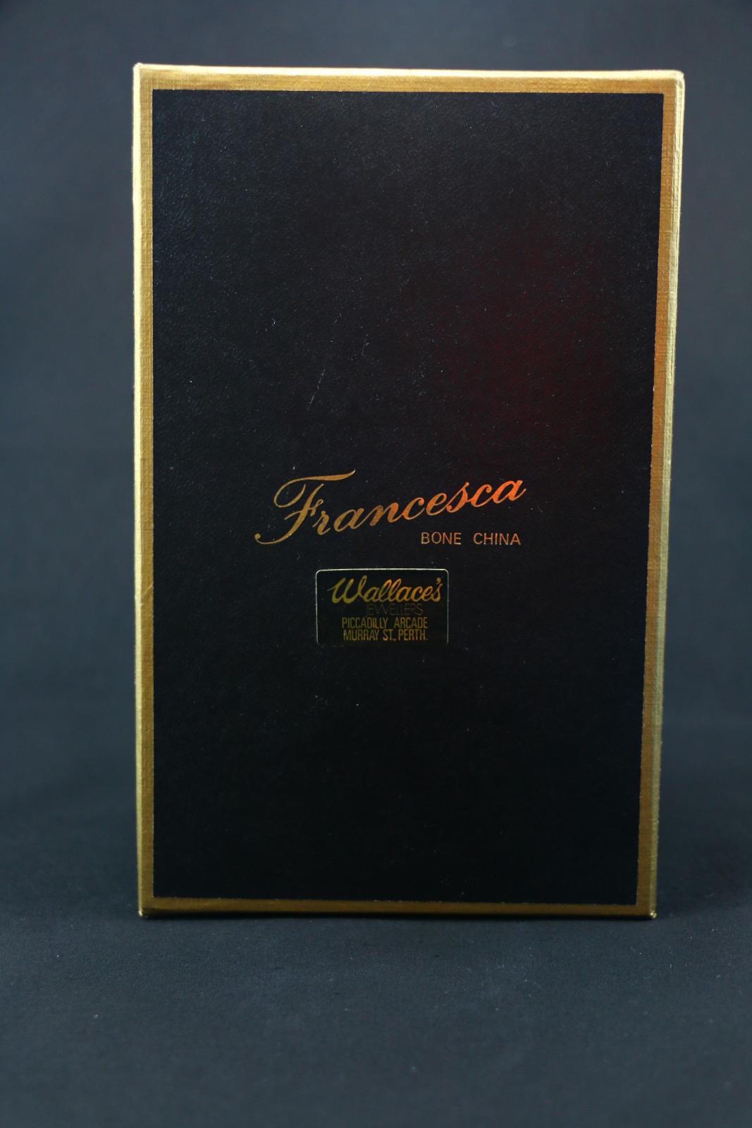 A rectangular black cardboard box with a gold rim around the top.