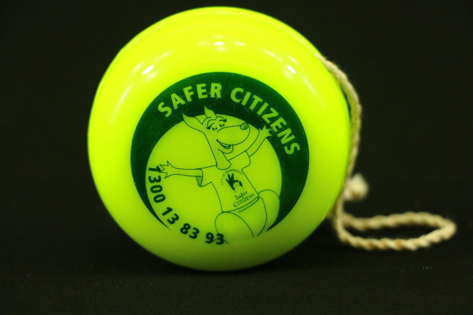 Round bright green plastic yo-yo with the City of Wanneroo "Community Kangaroo" pictured on each side. The inscription "SAFER CITIZENS' is above with "1300 13 83 93" in a semicircular shape below.