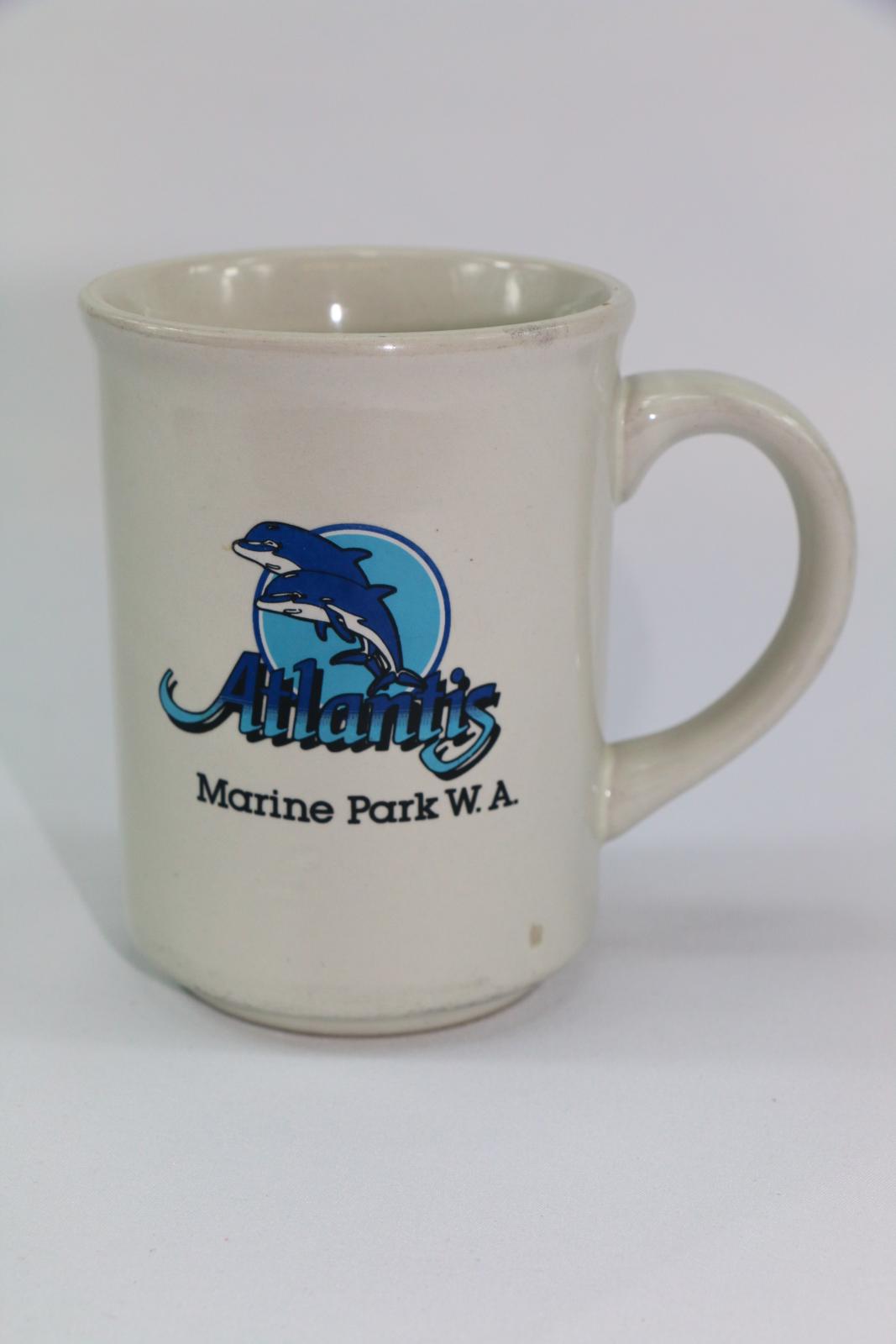 A white ceramic mug with Atlantis Marine Park logo on one side.