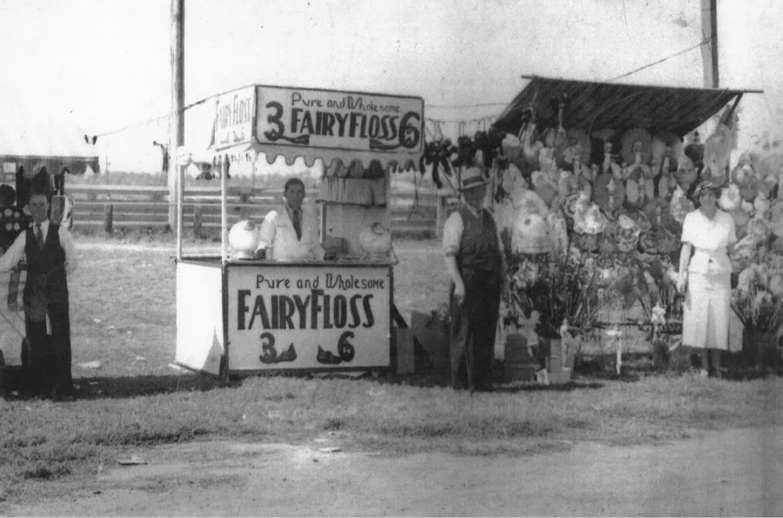 Man standing in front of fairy floss stand