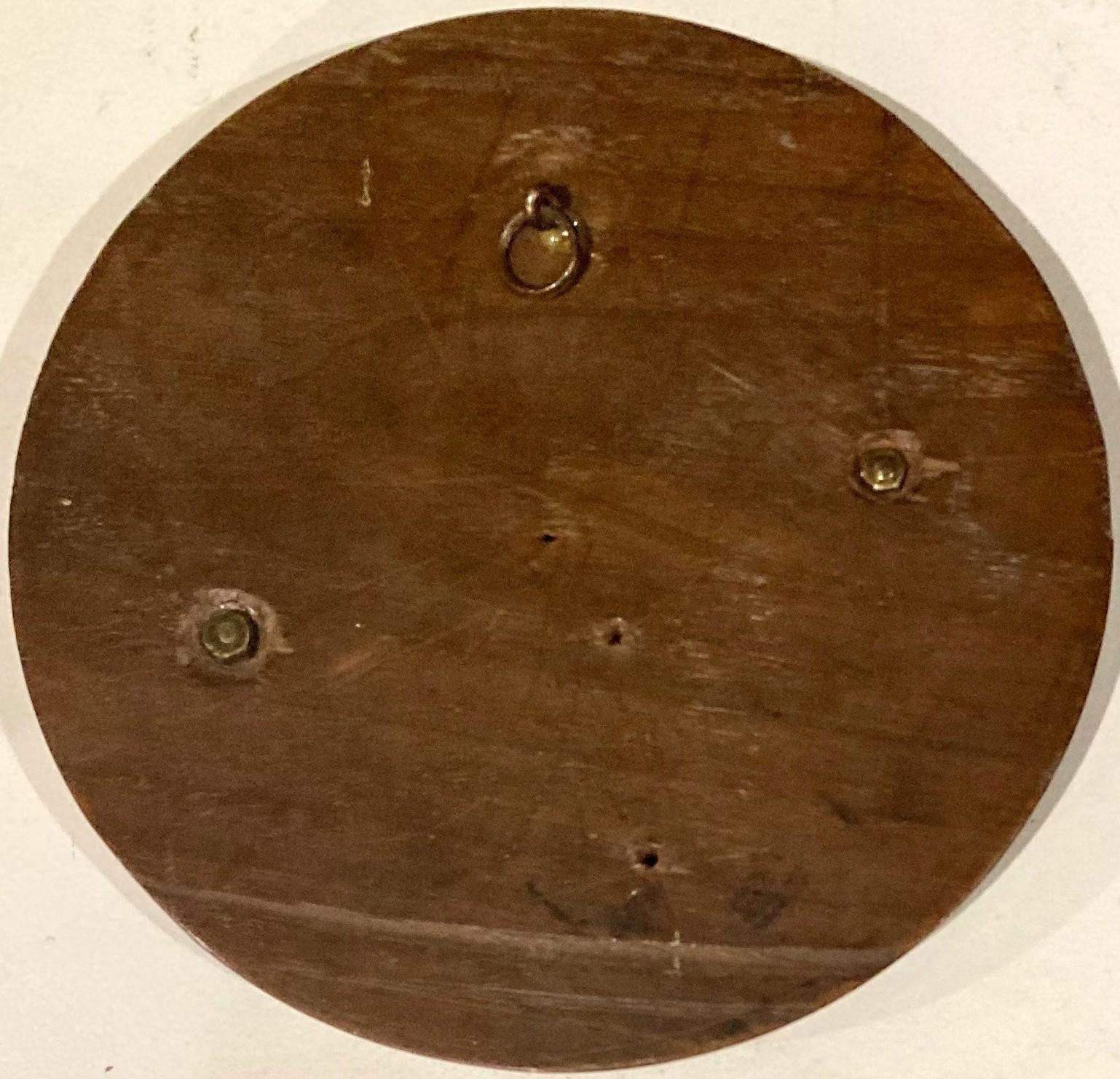 Reverse of bronze plaque showing timber base and metal hanging loop