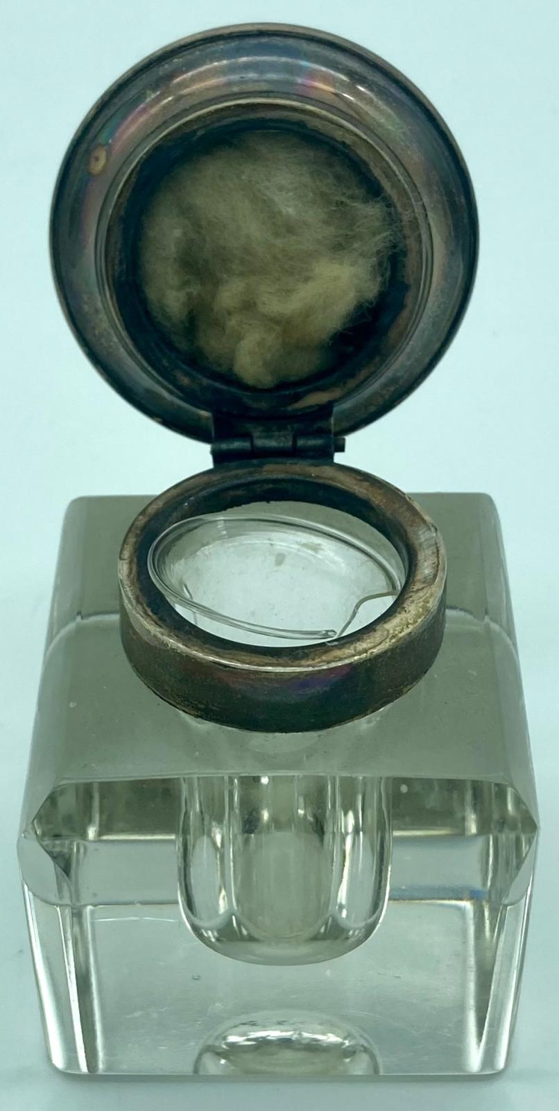 Side view of crystal glass inkwell with lid up, showing inside