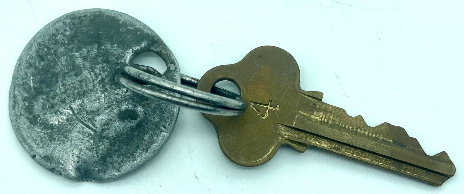 Reverse of well worn CGEF worker's token with Lockwood key attached